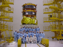 Cluster 2 spacecraft with a group of people in front